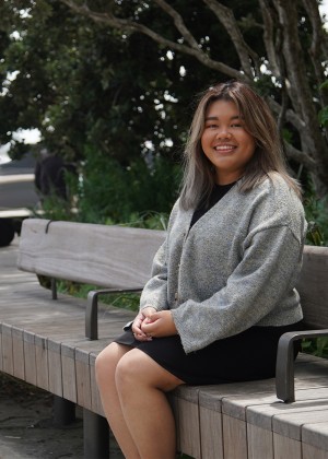 Angelika Tienzo sitting on a bench in downtown Auckland